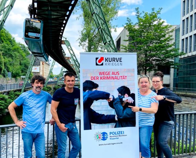 Das „Kurve kriegen“-Team Wuppertal vor der Wuppertaler Schwebebahn