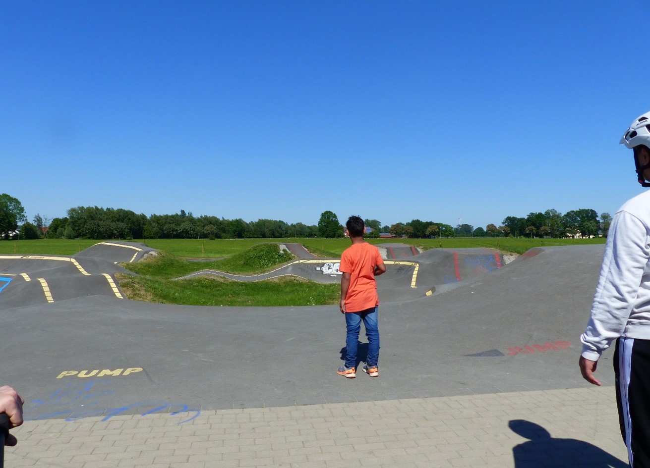 Zwei Personen schauen auf eine hügelige Betonpiste für Fahrräder